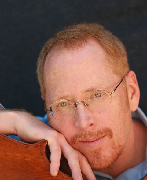 David Morris resting beside a string instrument
